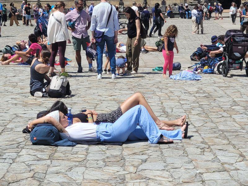 Turistas descansando en el Obradoiro