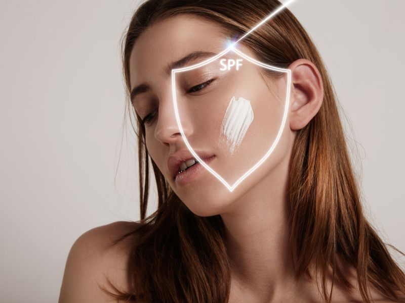 La cara de la mujer en un escudo hace que la proteccion spf contra el rayo