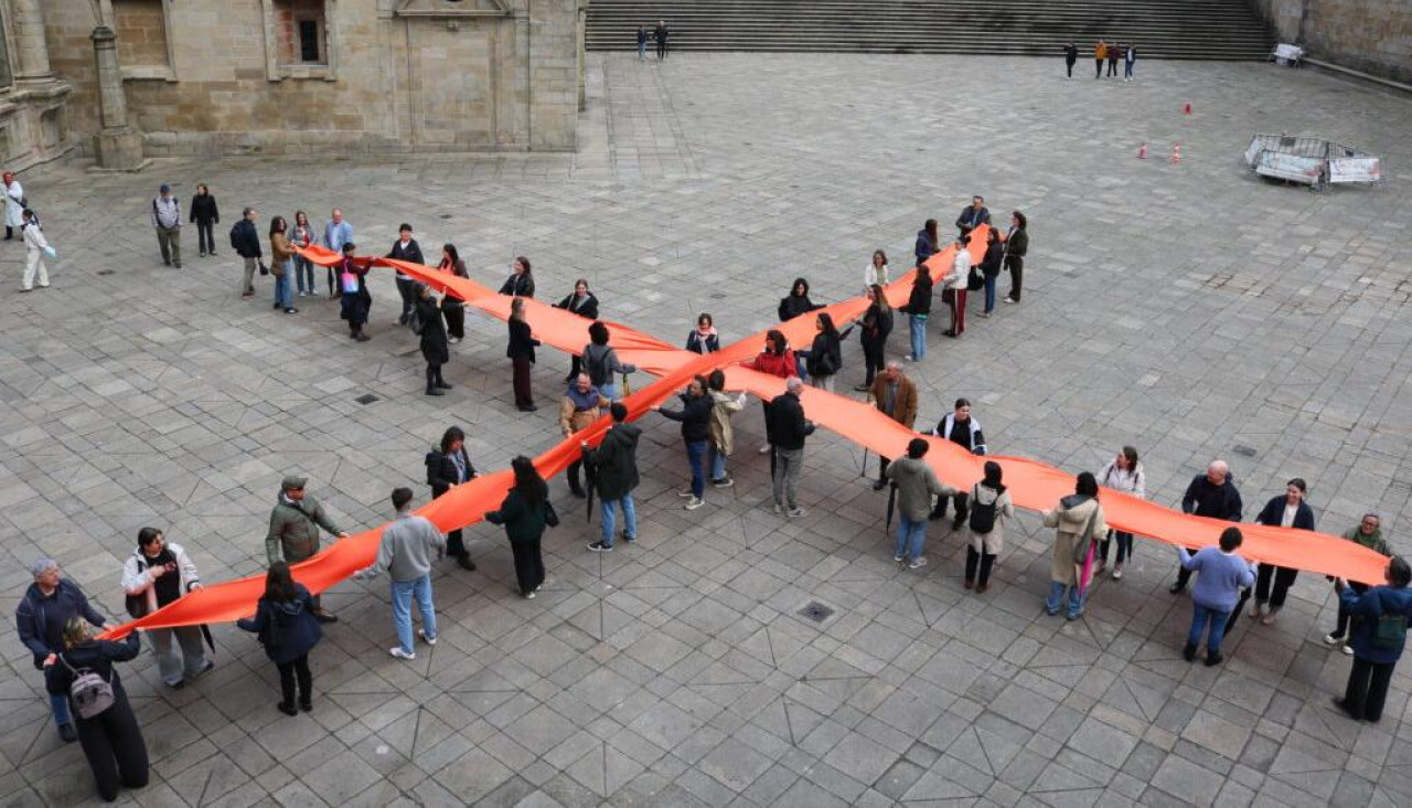 Representantes de organizaciones sociales se concentraron en la Praza da Quintana, en Santiago, con una gran “X” de tela para promover la asignación a fines sociales en la declaración de la renta