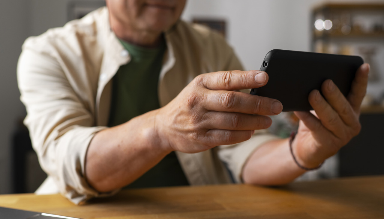 Retrato de un hombre mayor que usa un telefono inteligente en casa
