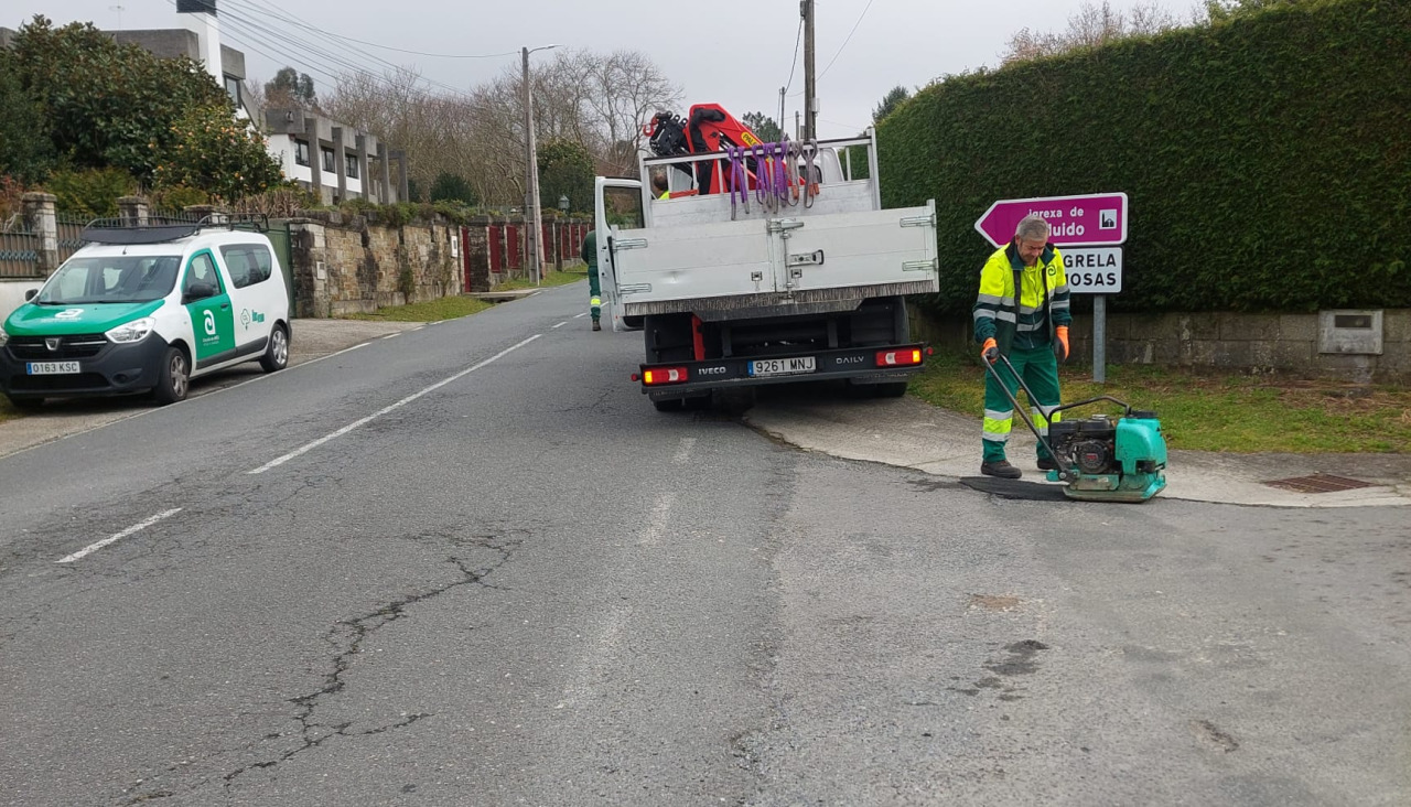 Traballadores da Brigada municipal de Obras de Ames executan a reparación de fochancas e mantemento do pavimento